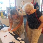 Katherine Krige signing a copy of one of her books for a fan. 